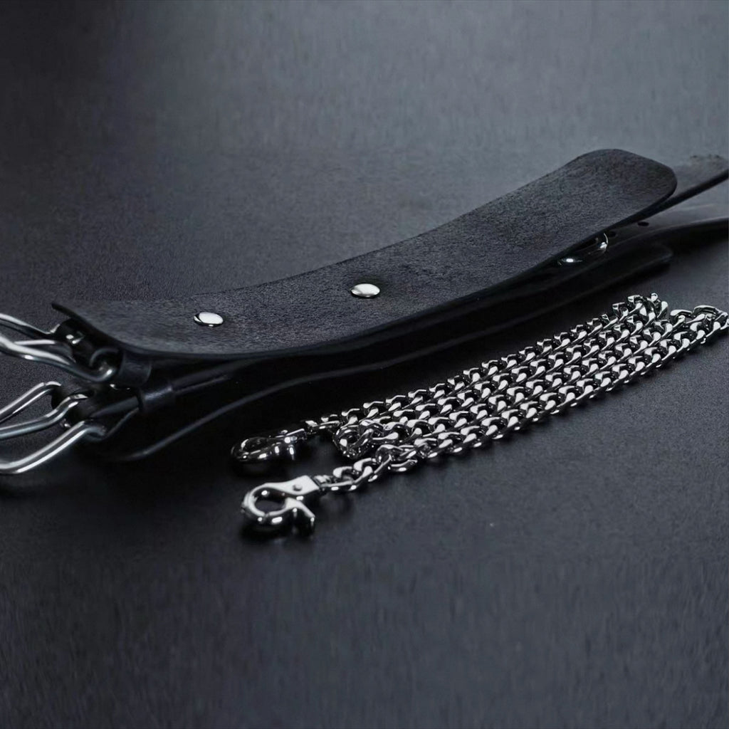Black leather wrist cuff side view with chain leash – silver rivet hardware clasp connector texture detail
