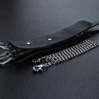 Black leather wrist cuff side view with chain leash – silver rivet hardware clasp connector texture detail
