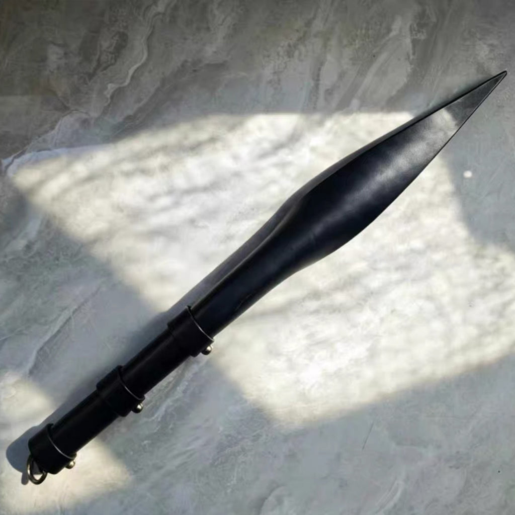Black leather soft paddle on white paper surface with natural light shadow – full profile leaf tip segmented handle BDSM
