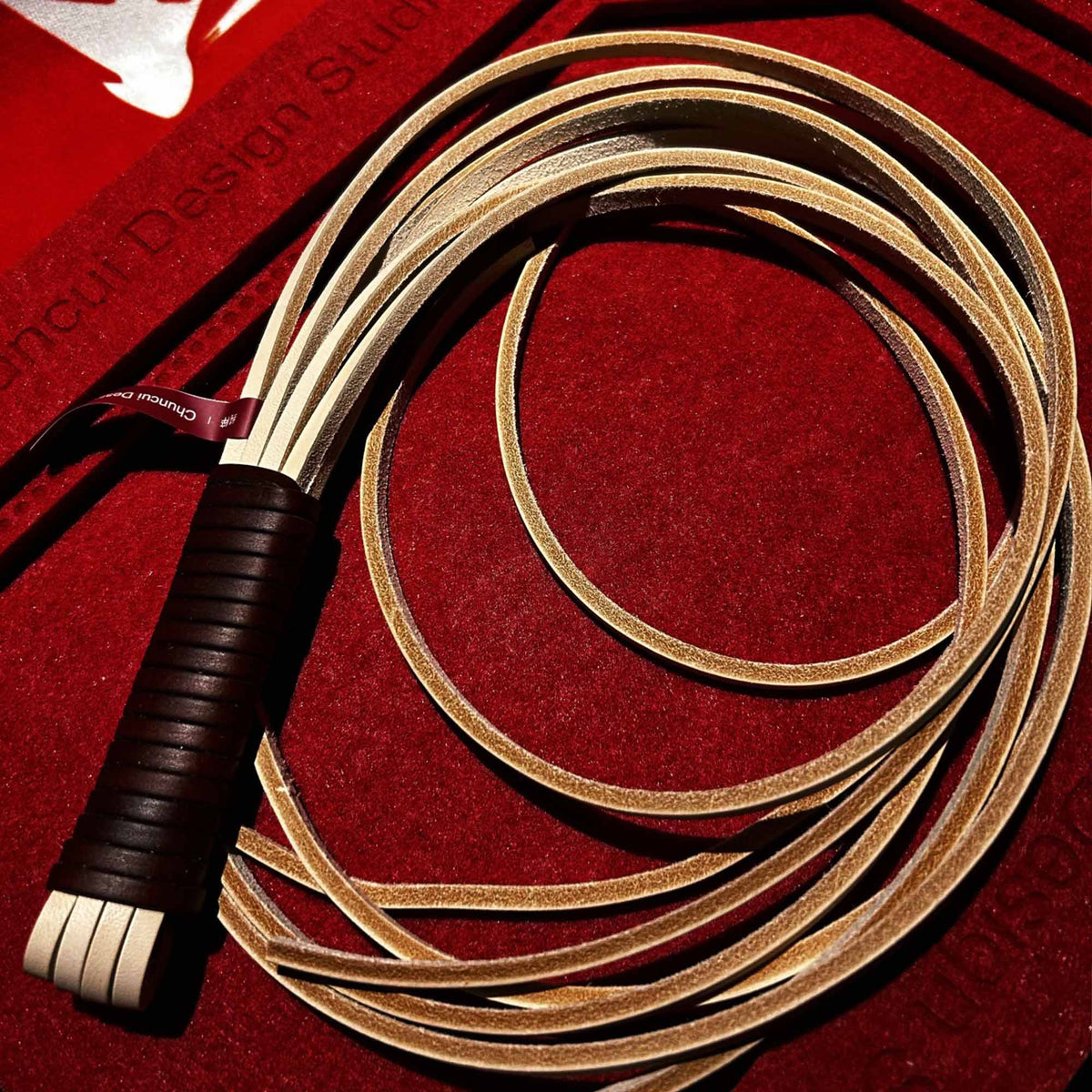 Natural vegetable tanned leather flogger product display – cream tails dark brown wrapped handle BDSM impact play handmade ShadowedBodies
