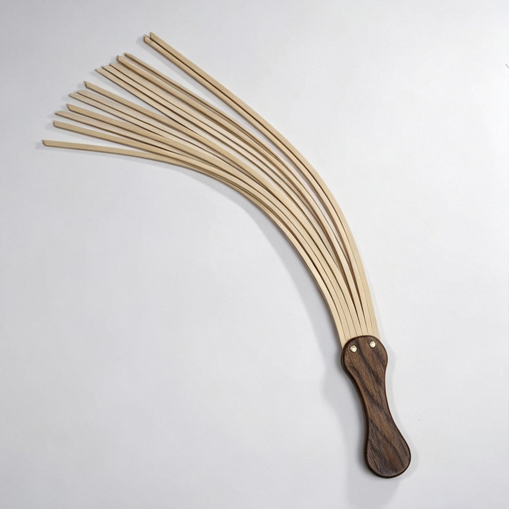 Natural tan leather flogger flat lay on white background – multiple tails fanned out walnut handle gold rivet full view BDSM
