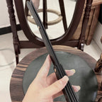 Black leather whip handle gripped overhead – double layer body gold rivet side texture full grain cowhide crop detail
