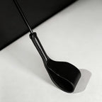 Black leather riding crop folded tip close-up – stitched neck connection vegetable tanned detail BDSM crop
