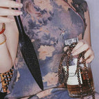 Black tooled leather paddle held in hand – intricate carved floral pattern leaf blade BDSM impact play lifestyle editorial
