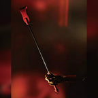 Red patent crocodile-embossed leather riding crop held by wooden mannequin hand – gold metal handle black rod red tip dramatic dark editorial BDSM
