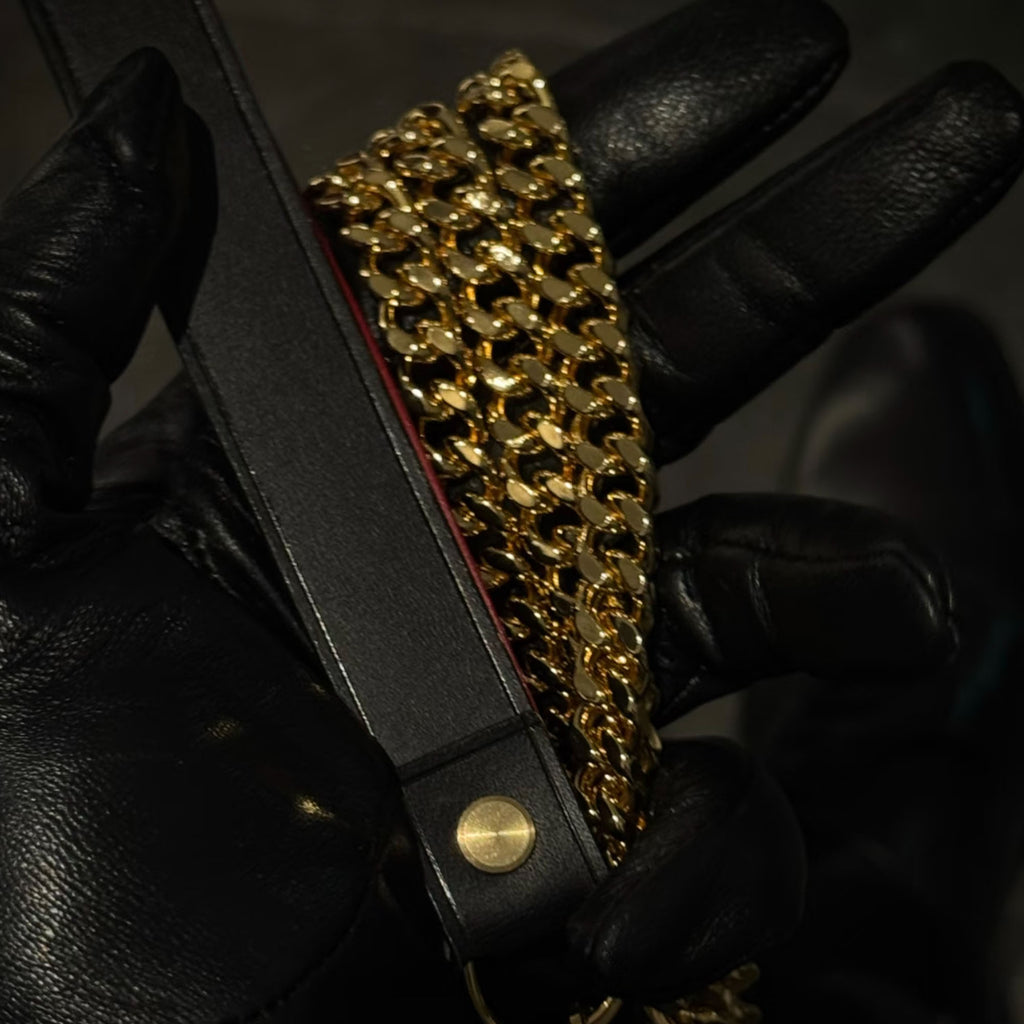 Black leather strap with gold Cuban link chain leash detail – gold dome rivet handmade BDSM leash close-up
