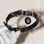 Black leather spiked choker front view in white gloved hands – silver square buckle O-ring custom charm pendant
