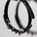 Matte black leather spiked choker hanging view – silver cone rivets double buckle BDSM collar side profile
