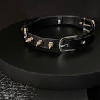 Matte black leather BDSM choker on black display stand – silver cone spike rivets double buckle dark editorial

