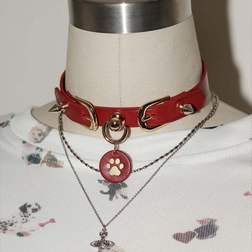 Red leather spiked choker on mannequin – gold hardware cone rivets custom tag pendant BDSM collar styled display
