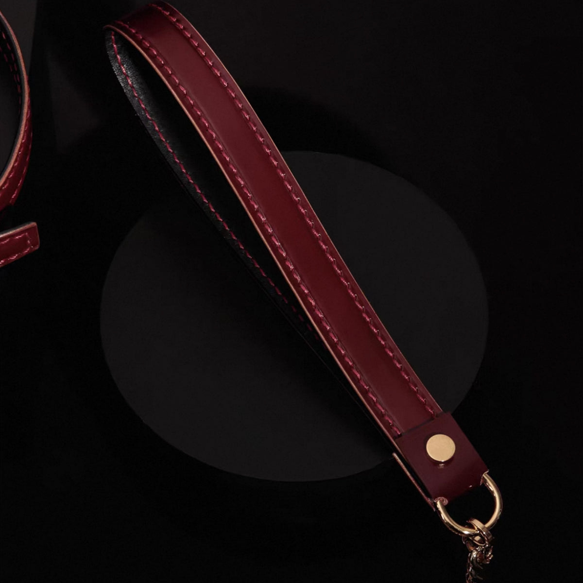 Burgundy leather leash strap detail – red saddle stitching gold dome rivet O-ring connector handmade
