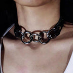 Front view of model wearing black leather collar linked together by three interlocking silver spring O-rings