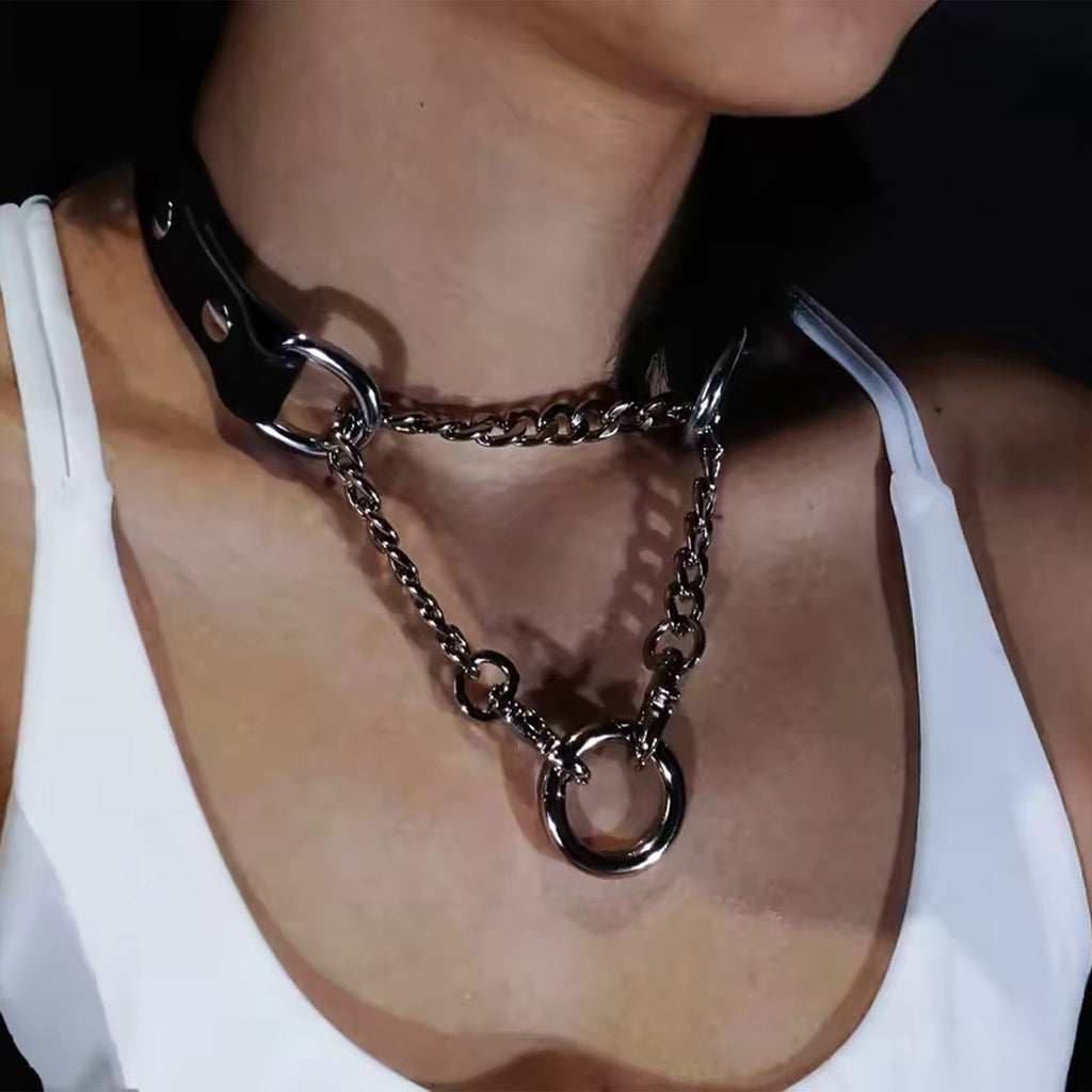 Frontal close-up of black leather collar featuring dual draped silver chains converging into a central O-ring